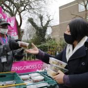 David L Williams, food bank volunteer and customer, serves venison at Ringcross Food Bank in Holloway