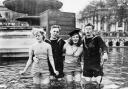 Two British sailors and their girlfriends wading in the fountains in Trafalgar Square on VE Day, 8 May