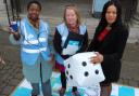 Volunteer Lawrencia Frempong, left, holds an air pollution monitor with volunteer Tiia Haataja, centre, and Cllr Claudia Webbe on the air pollution-themed snakes and ladders game. Picture: Islington Council