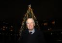 Former Arsenal captain Frank McLintock in front of the Highbury Square Christmas tree