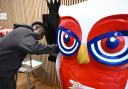 Arsenal's Bukayo Saka signs an owl sculpture ready for auction in aid of North London hospice