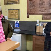 A local resident receives a laptop from Reverend Rosemia Brown, St James The Great church in Clapton.