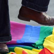 A person stamping on an LGBT pride flag