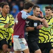 Referee Jarred Gillett is surrounded by players after disallowing a late Arsenal goal at Aston Villa