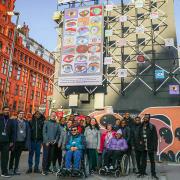 Students at New City College in front of their work at the 'digital canvas' near Old Street Roundabout in Shoreditch