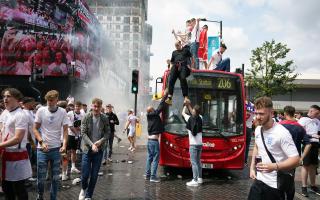 England fans climb aboard a bus outside the ground ahead of the UEFA Euro 2020 Final at Wembley Stadium