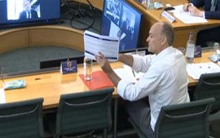 Dominic Cummings, former chief adviser to Prime Minister Boris Johnson, holds up a document whilst giving evidence to a joint inquiry of the Commons Health and Social Care and Science and Technology Committees on coronavirus