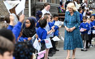 Queen Camilla is greeted by pupils in the courtyard of Moreland Primary School