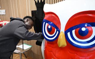 Arsenal's Bukayo Saka signs an owl sculpture ready for auction in aid of North London hospice